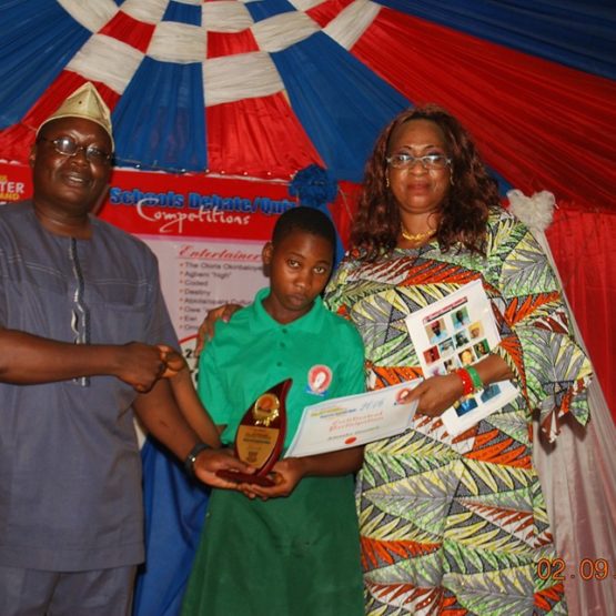 Dr Olusola Ogunsuyi presenting a plaque he donated to the winner of a student competition organized by the Igogo Daughter Association